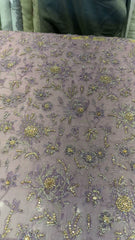 Detail of gold-tone and silver floral handwork on lilac formal
